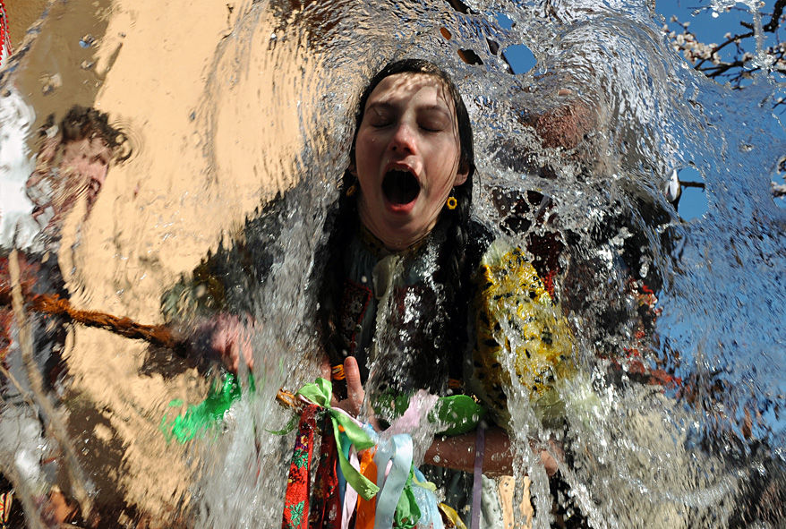 Young Slovaks dressed in traditional costumes throw a bucket of water at a girl as part of Easter celebrations in the village of Trencianska Tepla, north of Bratislava, April 9, 2012. (AFP)